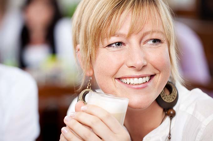 a woman smiling holding a beverage